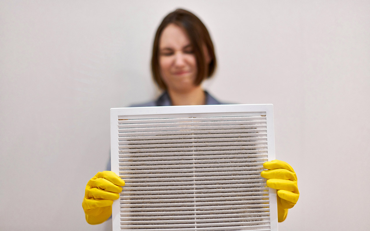 woman holding dirty air filter