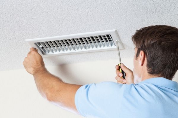 Man working on an air vent